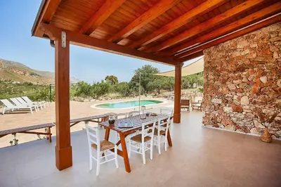 a patio with a table and chairs and a pool at Villa Ninfa in Castellammare del Golfo
