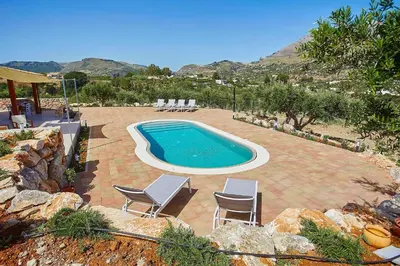 a swimming pool in a yard with chairs at Villa Ninfa in Castellammare del Golfo
