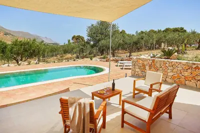 a patio with a table and chairs and a pool at Villa Ninfa in Castellammare del Golfo