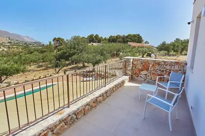 a balcony with two chairs and a swimming pool at Villa Ninfa in Castellammare del Golfo