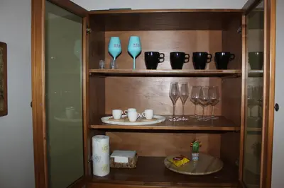 a wooden shelf with glasses and wine glasses at Casa Vacanze In Piazza in Terrasini