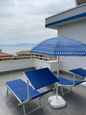two blue chairs and an umbrella on a roof at Casa Vacanze Villa Lena in Santa Flavia