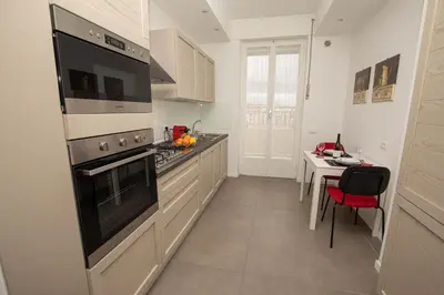 a white kitchen with a stove and a table at Nothotel delle Rose in Palermo