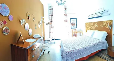 a bedroom with a bed and a desk and plates on the wall at Casa Dam'Arte in Palermo