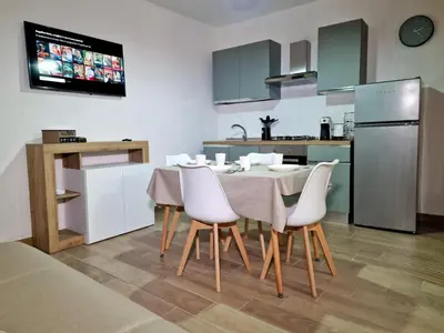 a kitchen with a table and white chairs in a room at DIMORA SAITTA per SAITTA HOLIDAYS in Palermo
