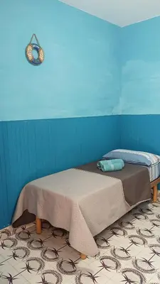 a bed in a room with a blue wall at LA TERRAZZA SUL MARE camera doppia vicino aereoporto&mare SICILIAN SEA STYLE ROOM in Cinisi