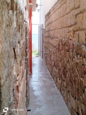 an alley between two brick walls with the ocean in the background at LA TERRAZZA SUL MARE camera doppia vicino aereoporto&mare SICILIAN SEA STYLE ROOM in Cinisi