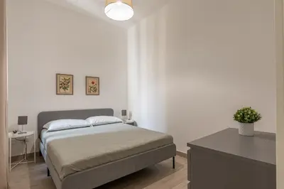 a white bedroom with a bed and a table at La casa sul Mercato by Wonderful Italy in Palermo