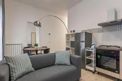 a living room with a gray couch and a kitchen at La casa sul Mercato by Wonderful Italy in Palermo