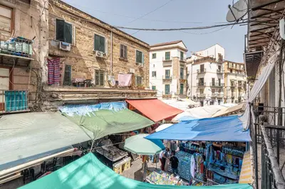 an outdoor market in an alley with buildings at La casa sul Mercato by Wonderful Italy in Palermo