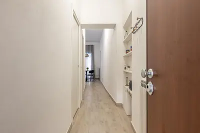 a hallway with white walls and a wooden door at La casa sul Mercato by Wonderful Italy in Palermo