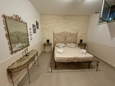 a bedroom with a bed and a mirror and a chair at Mondello Telemaco Beach in Palermo