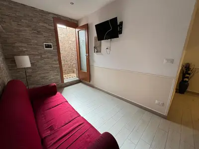 a living room with a red couch and a tv at Mondello Telemaco Beach in Palermo