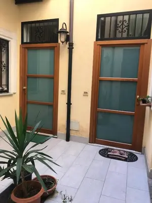 a house with two doors and a potted plant at Little house of Grandpa Antonio in Palermo