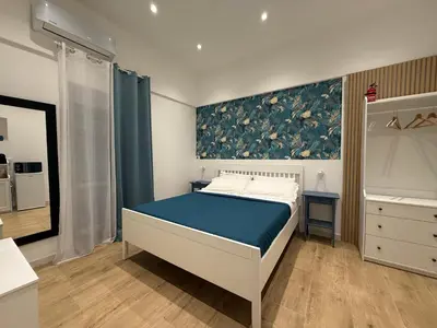 a bedroom with a bed and a painting on the wall at La Quas at in Palermo