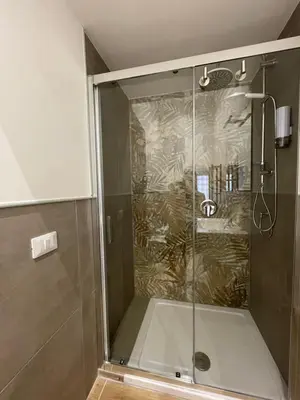 a shower with a glass door in a bathroom at La Quas at in Palermo
