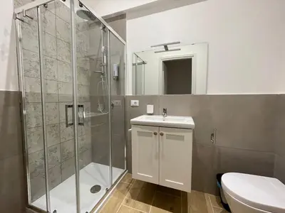 a bathroom with a shower and a sink and a toilet at La Quas at in Palermo