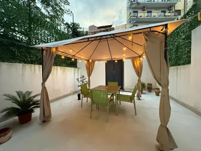 a patio with a table and chairs under a canopy at La Quas at in Palermo