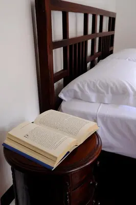 an open book sitting on a table next to a bed at Maison al Massimo - City Center Full Apartment in Palermo