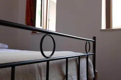 a bed with a metal rail in a bedroom at Maison al Massimo - City Center Full Apartment in Palermo