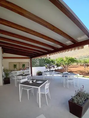 a patio with white tables and white chairs at Olea in Castelluzzo