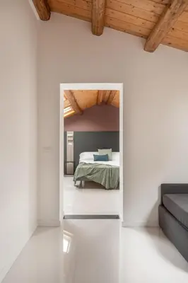 a bedroom with a bed in a room with white walls at La Terrazza su Dante Rooms in Palermo