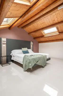 a bedroom with a bed with wooden ceilings and skylights at La Terrazza su Dante Rooms in Palermo