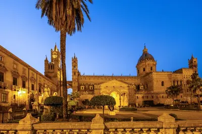 a large building with a palm tree in front of it at Cathedral Room&Loft in Palermo