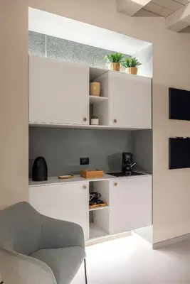a living room with white shelves and a chair at Cathedral Room&Loft in Palermo