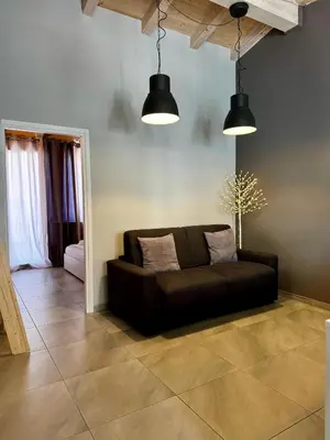 a black couch in a living room with two lights at La Piazzetta a Mare Holiday House in Sferracavallo
