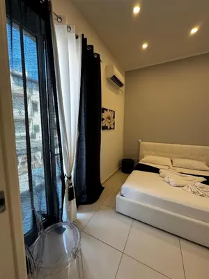 a bedroom with a bed and a large window at La Piazzetta a Mare Holiday House in Sferracavallo