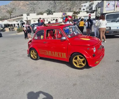 a small red car is driving down the street at Onda blu in Carini