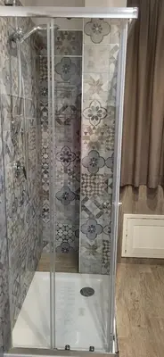 a shower with a glass door with skulls on the wall at De Luca in Palermo