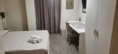 a hotel room with a bed and a desk at De Luca in Palermo
