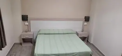 a bedroom with a bed with two nightstands and two tables at De Luca in Palermo