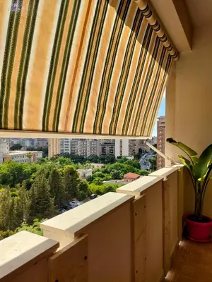 a window with a striped curtain and a plant on a balcony at D'Amelio Sweet Home in Palermo