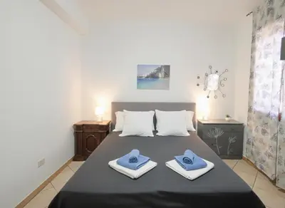 a bedroom with a bed with blue towels on it at Villasara Scopello relax con 4 camere piscina&SPA in Castellammare del Golfo