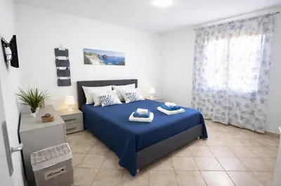 a bedroom with a blue bed with towels on it at Villasara Scopello relax con 4 camere piscina&SPA in Castellammare del Golfo