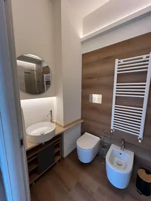 a bathroom with a sink and a toilet and a mirror at LaPignaVerde in Palermo