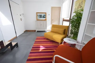 a living room with a yellow couch and a rug at iFlat Corte Seralcadi in Palermo