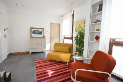 a living room with a yellow chair and a rug at iFlat Corte Seralcadi in Palermo