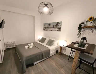 a bedroom with a bed and a table and a desk at Casa vacanze green house in Terrasini