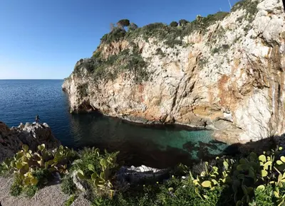 a large rock cliff next to a body of water at Casa vacanze green house in Terrasini