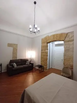 a living room with a couch and a chandelier at Residenza del Massimo in Palermo