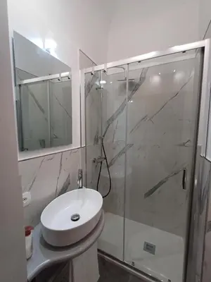 a bathroom with a glass shower and a sink at Residenza del Massimo in Palermo