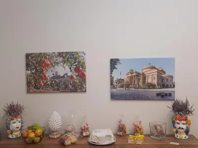 a shelf with vases and paintings on a wall at Residenza del Massimo in Palermo