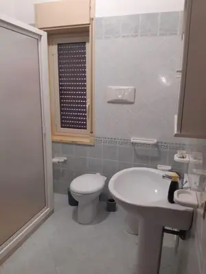 a white bathroom with a toilet and a sink at Nonna Giovanna in Castellammare del Golfo