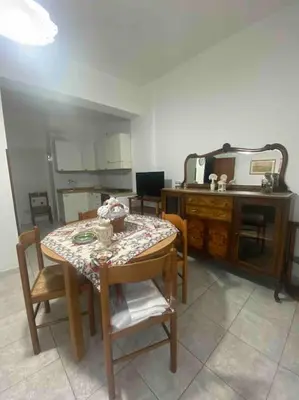 a kitchen with a table and chairs and a table and a microwave at Nonna Giovanna in Castellammare del Golfo