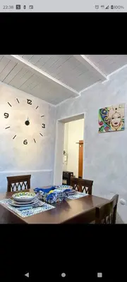 a dining room table with a clock on the wall at Casa Patry in Palermo