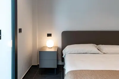 a bedroom with a bed and a lamp on a night stand at Villa Tina Mondello in Mondello